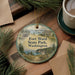 A round ornament with a scenic image of Fort Washington State Park, Washington, surrounded by pine branches and a cup of coffee on a wooden surface.