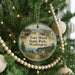 A round ornament hanging on a Christmas tree, featuring a scenic image of Fort Washington State Park in Washington, with a house and a boat in the background.