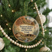 A round ornament hanging on a Christmas tree, featuring a scenic image of the Fremont Indian State Park and Museum in Utah.