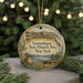 A round ornament with a painting of a historical site, specifically Ganondagan State Historic Site in New York, hanging from a string.