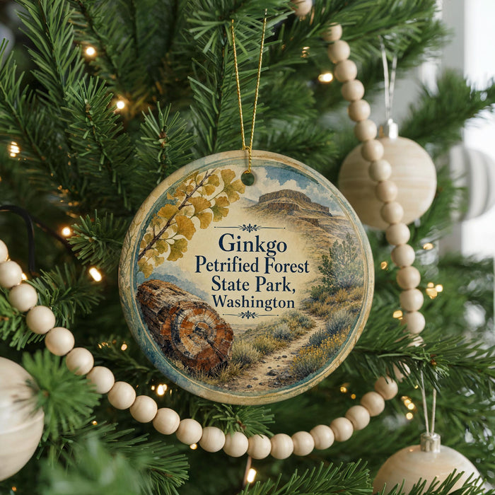 A round ornament hanging on a Christmas tree, featuring a scenic image of Ginkgo Petrified Forest State Park in Washington.