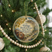 A round ornament hanging on a Christmas tree, featuring a scenic image of Ginkgo Petrified Forest State Park in Washington.