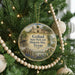 A round ornament hanging on a Christmas tree, featuring a scenic image of a historic site in Texas.