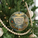 A round ornament hanging on a Christmas tree, featuring a scenic image of the Peshtigo River and the Wisconsin State Forest.