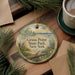 A decorative ornament with the text "Grass Point State Park, New York" on it, surrounded by pine branches and a cup of coffee on a wooden surface.