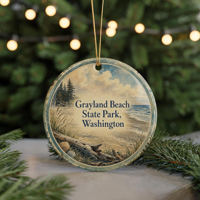A circular ornament with a beach scene and text, hanging in front of a blurred background with Christmas lights.