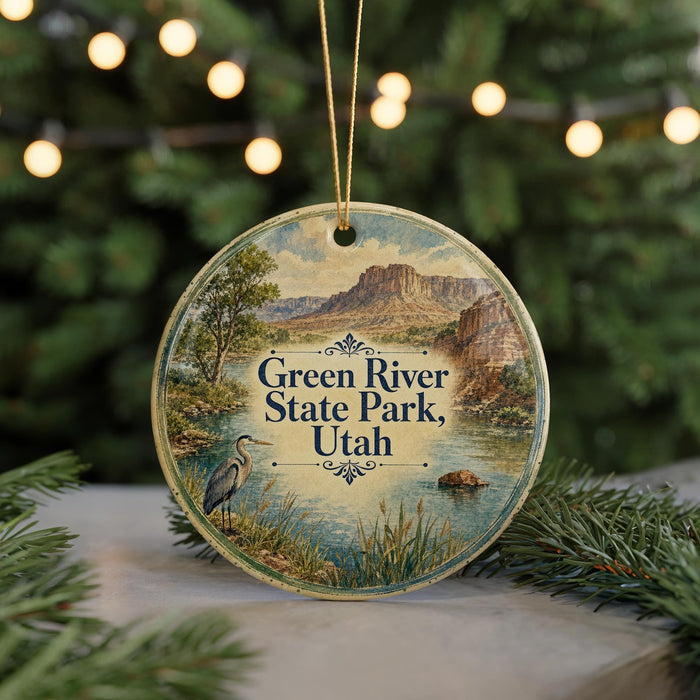 A circular ornament with a scenic landscape of the Green River State Park in Utah, featuring a heron and a mountain backdrop.