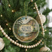A Christmas tree decorated with ornaments, including a circular ornament with a scenic landscape of Greenleaf State Park, Oklahoma.