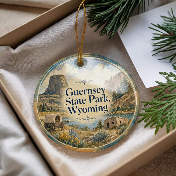 A decorative ornament with a scenic image of Guernsey State Park, Wyoming, hanging from a string.