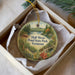 A round ornament with a scenic landscape of Half Moon Pond State Park, Vermont, displayed in a box with a white tissue paper lining.