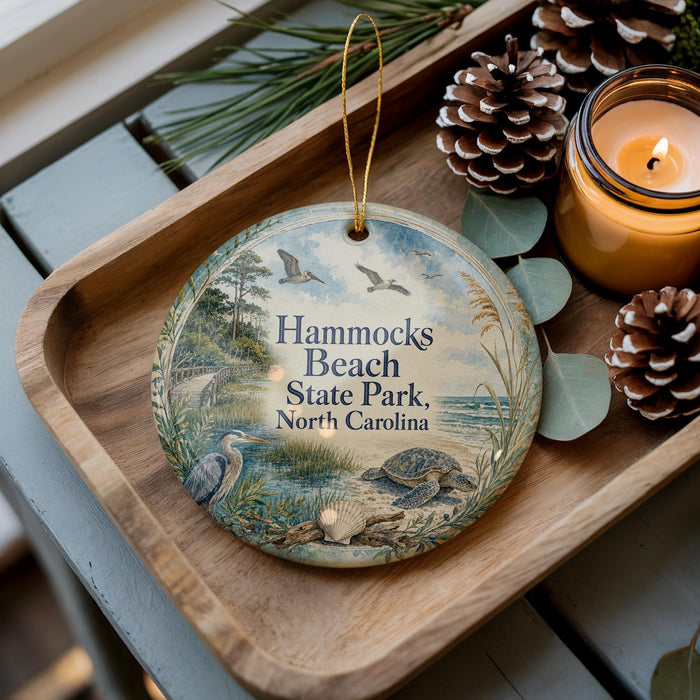 A decorative ornament with a bird and a turtle on it, placed on a wooden tray next to pine cones and a lit candle.