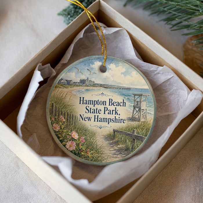 A decorative ornament in a box, featuring a scenic image of Hampton Beach State Park in New Hampshire.