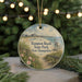 A decorative ornament featuring a beach scene with a lifeguard tower, surrounded by greenery and a string of lights in the background.