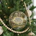 A round ornament hanging on a Christmas tree, featuring a painting of a historic plantation house surrounded by trees and a pond.