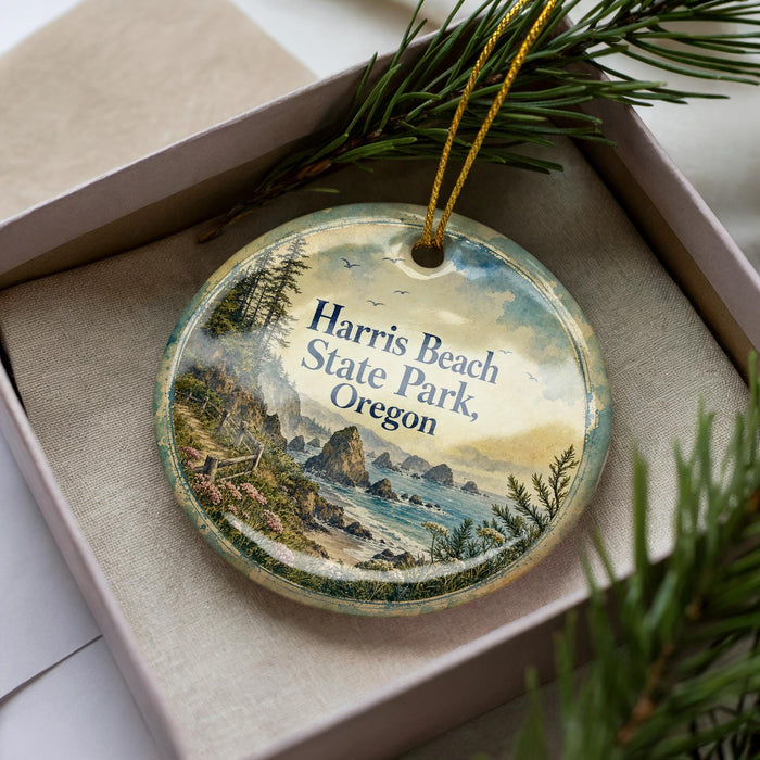 A decorative ornament in a box, featuring a scenic landscape with mountains, water, and pine trees.
