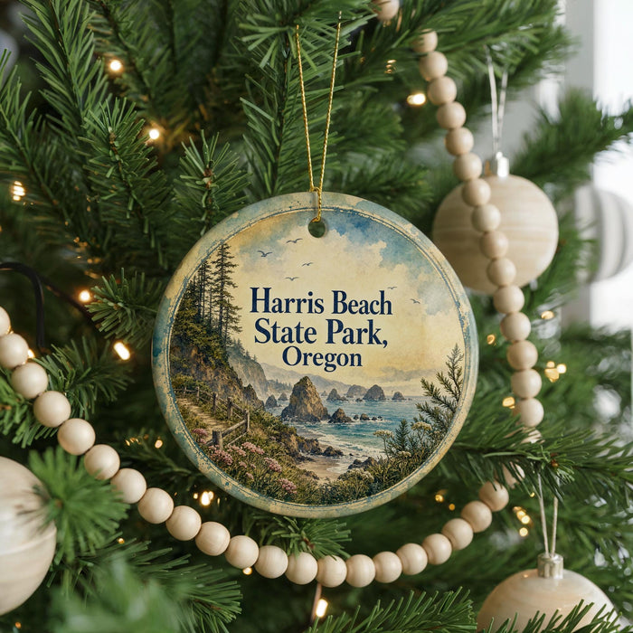 A round ornament hanging on a Christmas tree, featuring a scenic landscape of the coastal region of Oregon.