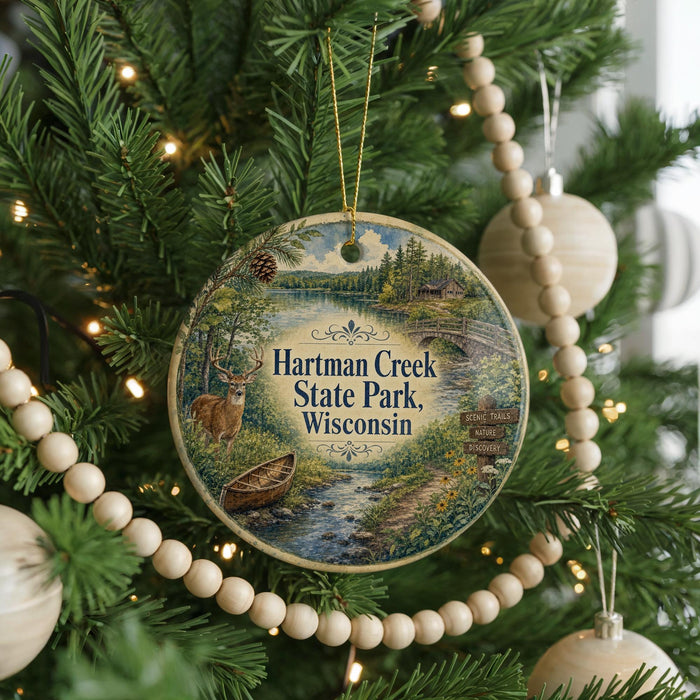 A round ornament hanging on a Christmas tree, featuring a scenic image of Hartman Creek State Park, Wisconsin.