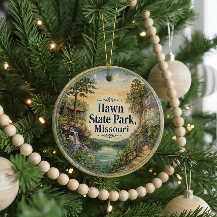 A round ornament hanging on a Christmas tree, featuring a scenic image of Hawn State Park, Missouri.