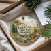 A round ornament with a landscape scene featuring Hell Creek State Park, Montana, hanging from a string.