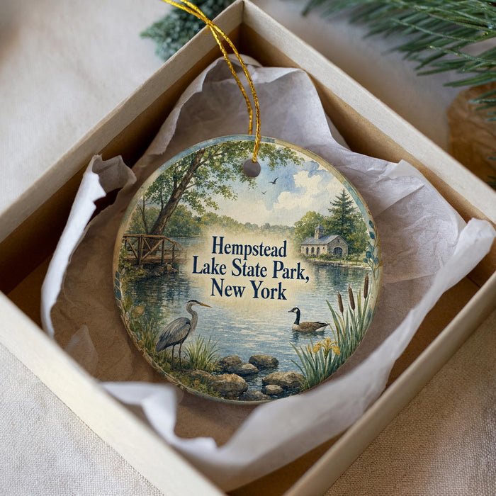 A decorative ornament in a box, featuring a scenic image of Hempstead Lake State Park in New York.