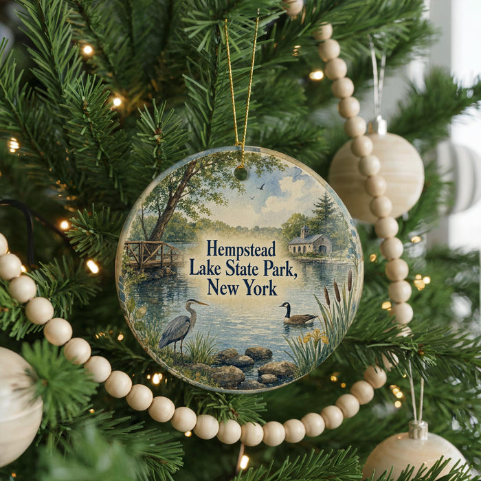 A round ornament hanging on a Christmas tree, featuring a scenic image of a lake and surrounding landscape.