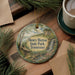 A round ornament with a scenic image of Henry Horton State Park, Tennessee, hanging on a wooden surface.