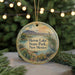 A round ornament with a scenic landscape of a lake, mountains, and a heron, hanging from a string.
