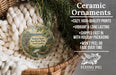 Ceramic ornaments, featuring a ceramic ornament with a scenic landscape and text, are displayed in a basket with greenery.