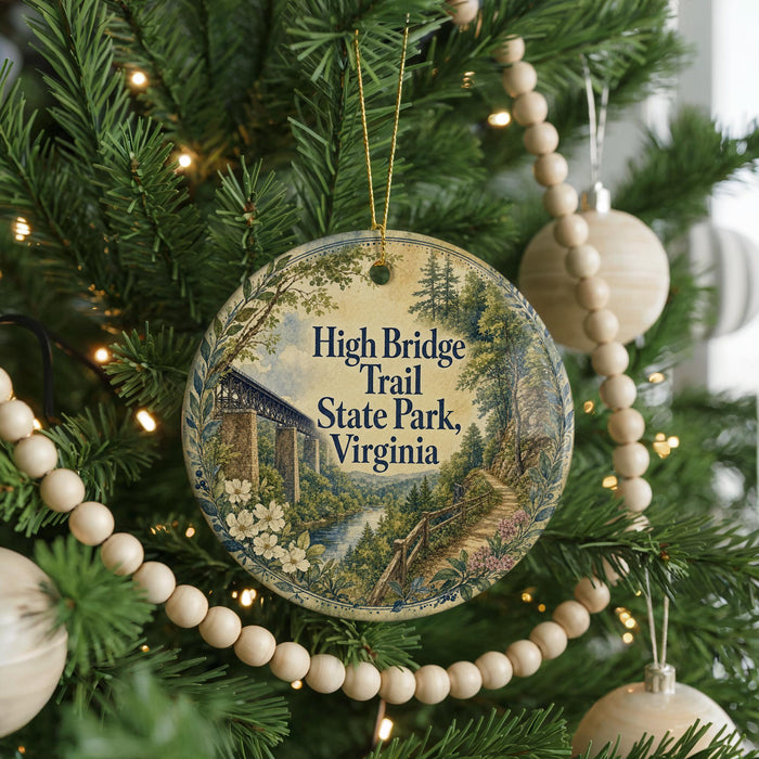 A round ornament hanging on a Christmas tree, featuring an illustration of the High Bridge Trail in Virginia.