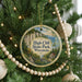 A round ornament hanging on a Christmas tree, featuring a scenic image of High Cliff State Park in Wisconsin.