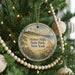 A Christmas tree decorated with ornaments, including a round ornament with a lighthouse and a beach scene, surrounded by lights and greenery.