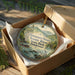 A decorative ornament in a wooden box, featuring a scenic image of the Hwassee River and Tennessee State Park.