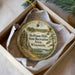 A round ornament with a scenic landscape of Hoffman Hills, Wisconsin, hanging from a string.