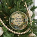 A round ornament hanging on a Christmas tree, featuring a scenic image of Huesston Woods State Park, Ohio.