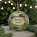A round ornament with a nature scene and text, hanging on a string.