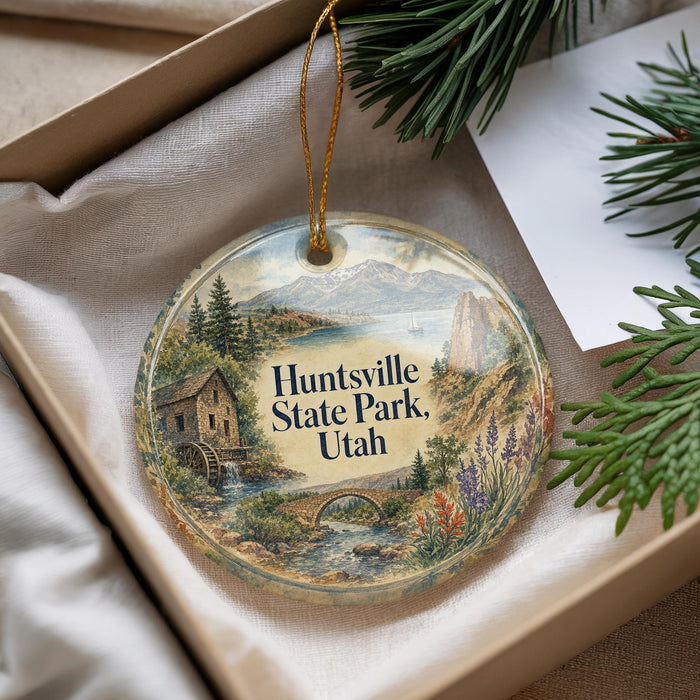 A decorative ornament with a scenic landscape of a cabin, river, and mountains, featuring the text "Huntsville State Park, Utah".