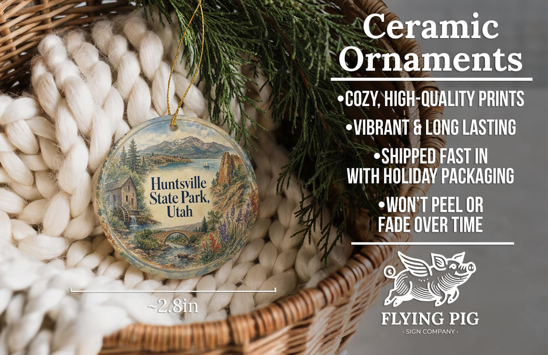 Ceramic ornaments, featuring a detailed illustration of Huntsville State Park in Utah, are displayed in a woven basket.