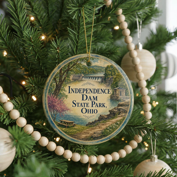 A round ornament on a Christmas tree, featuring a scenic image of Independence Dam State Park, Ohio.