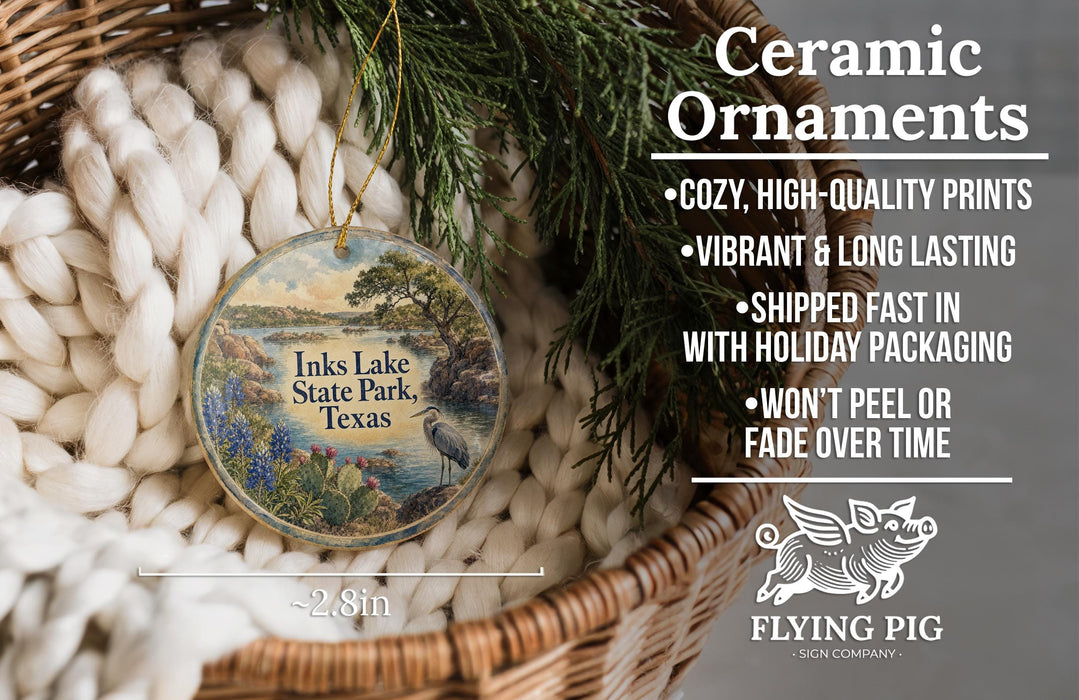 Ceramic ornaments, featuring a bird and a landscape, are displayed in a basket with greenery.