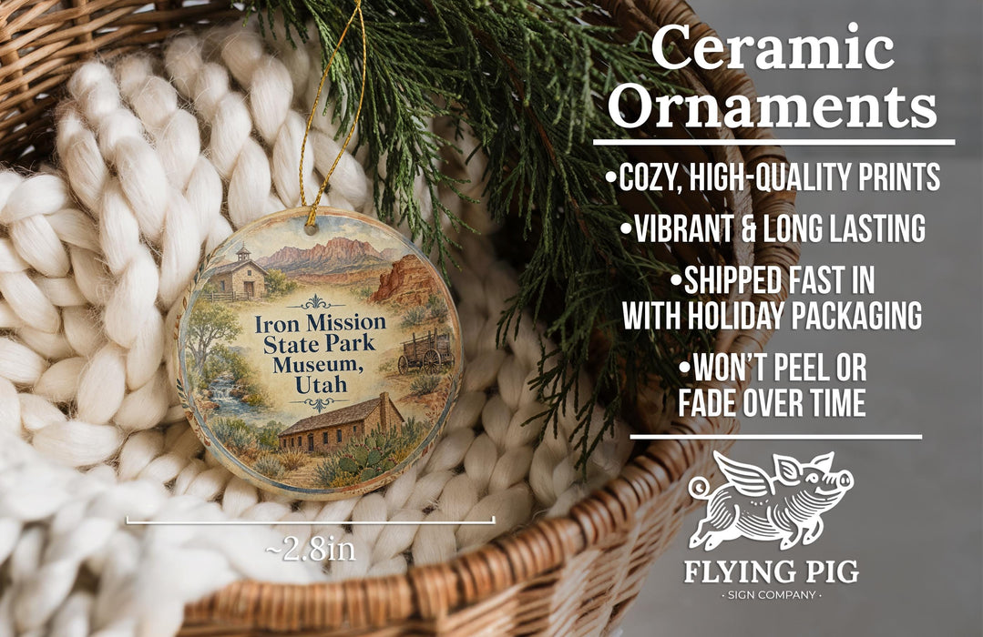 Ceramic ornaments, featuring a detailed illustration of Iron Mission State Park Museum in Utah, are displayed in a woven basket.