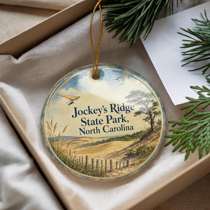 A round ornament with a scenic landscape of Jockey's Ridge State Park, North Carolina, hanging from a string.