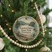 A circular ornament hanging on a Christmas tree, featuring a scenic landscape of Kanaskat-Palmer State Park in Washington.