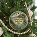 A round ornament hanging on a Christmas tree, featuring a scenic image of Kelley's Island State Park, Ohio.