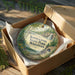A decorative ornament in a wooden box, featuring a scenic landscape with a waterfall and trees, with the text "Kinnickinnic State Park, Wisconsin" prominently displayed.