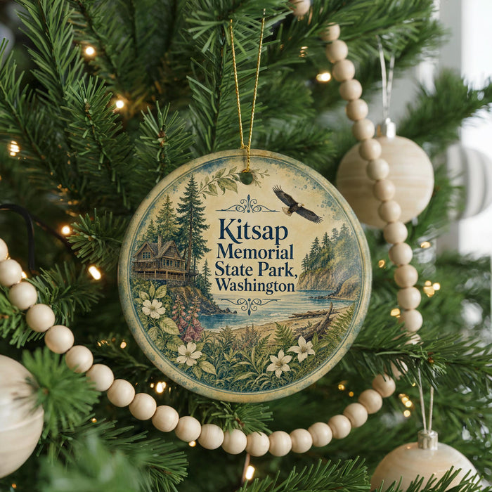 A round ornament hanging on a Christmas tree, featuring a scenic landscape with a lake, mountains, and a cabin.