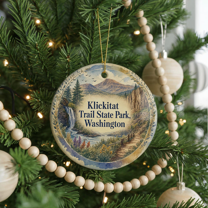 A Christmas tree decorated with ornaments, including a circular ornament with a scenic image of Klickitat Trail State Park in Washington.