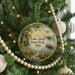 A round ornament hanging on a Christmas tree, featuring a scenic image of Lake Alma State Park, Ohio.