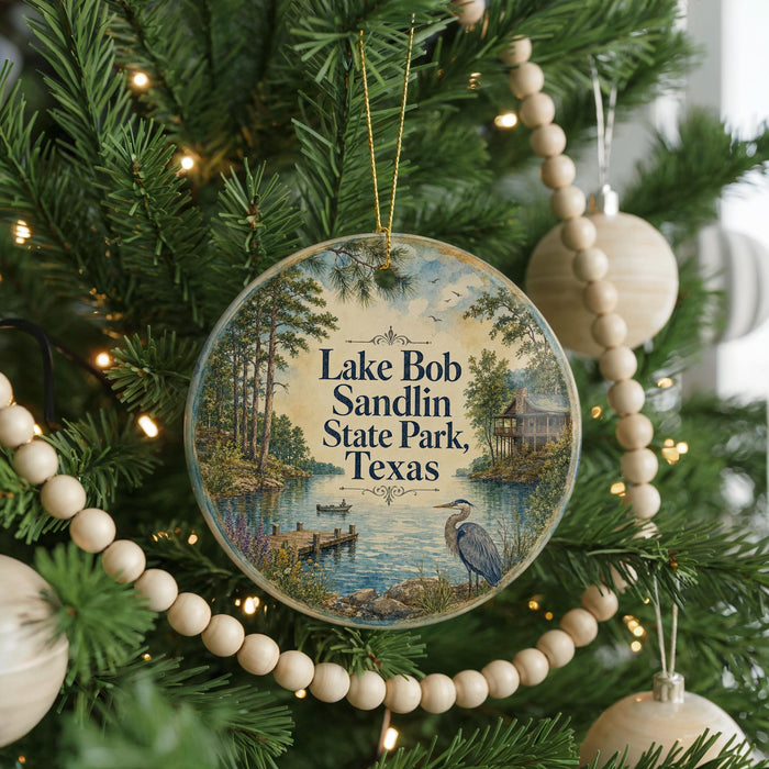 A round ornament hanging on a Christmas tree, featuring a scenic image of Lake Bob Sandlin State Park, Texas.