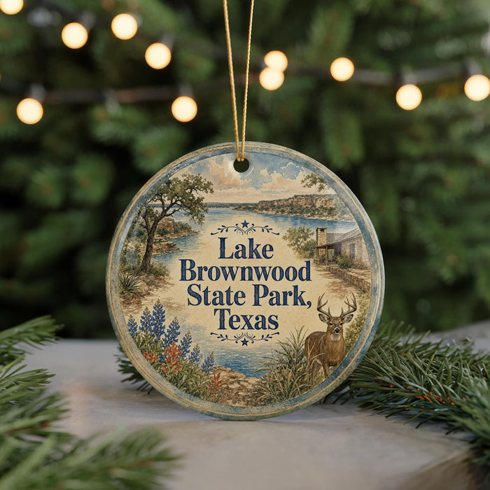 A round ornament with a scenic image of Lake Brownwood State Park, Texas, featuring a deer in the foreground and a backdrop of trees and water.