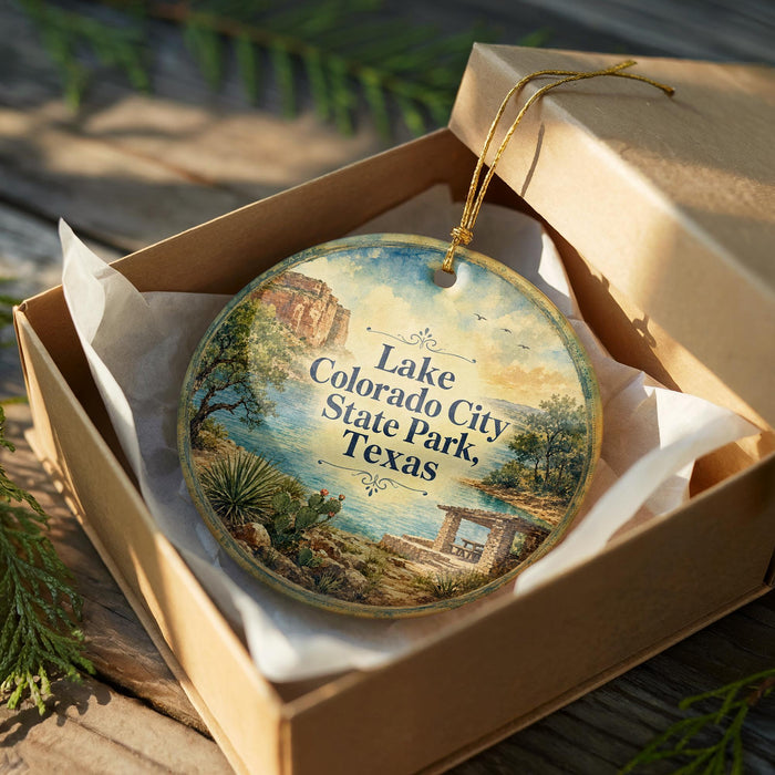 A decorative ornament in a box, featuring a scenic landscape with a lake, mountains, and a bridge.